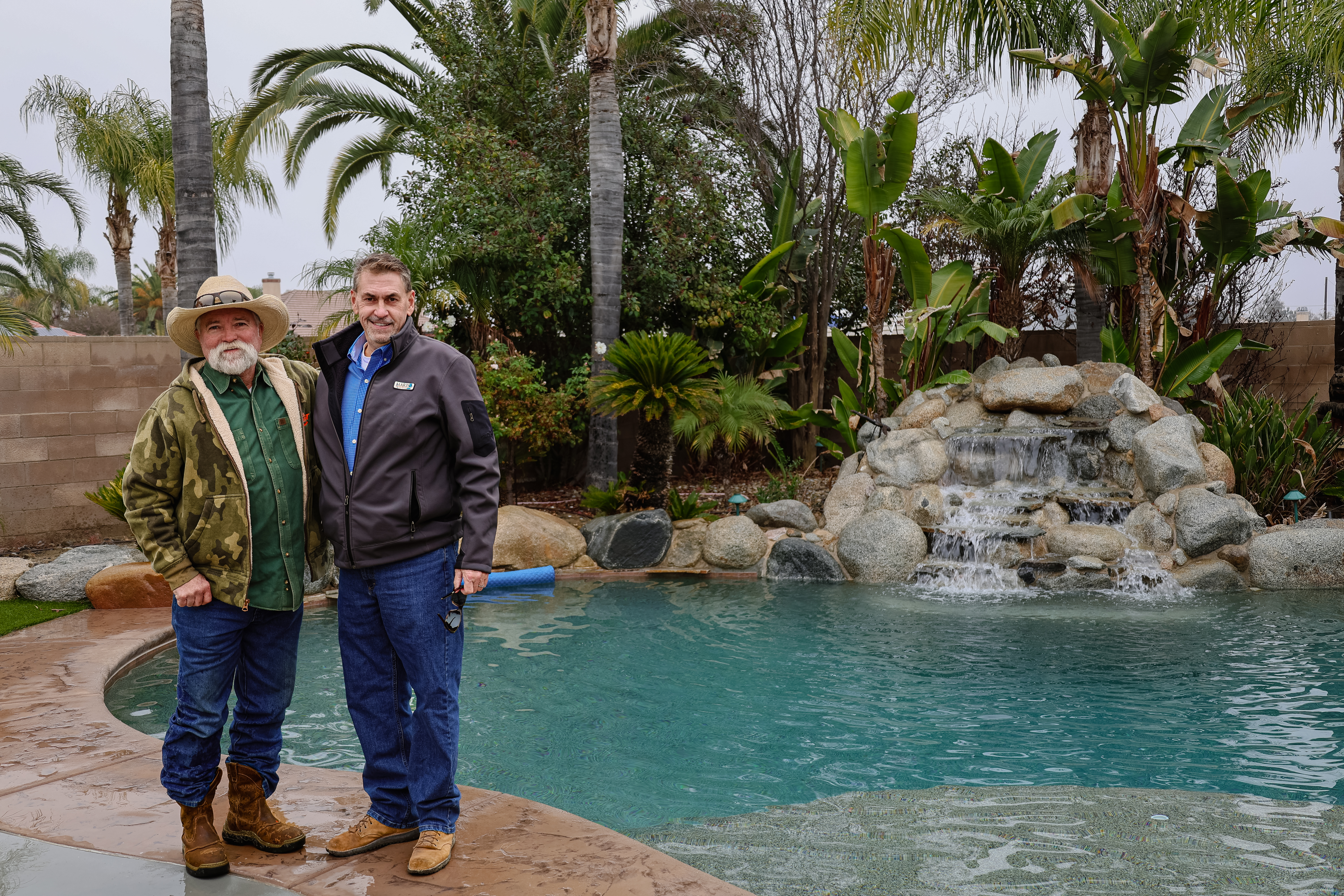 Chad Rogers, Marina Pool Company, and Mike Jones, Mr. Bobcat Excavation, Inc., standing together at a completed backyard pool site